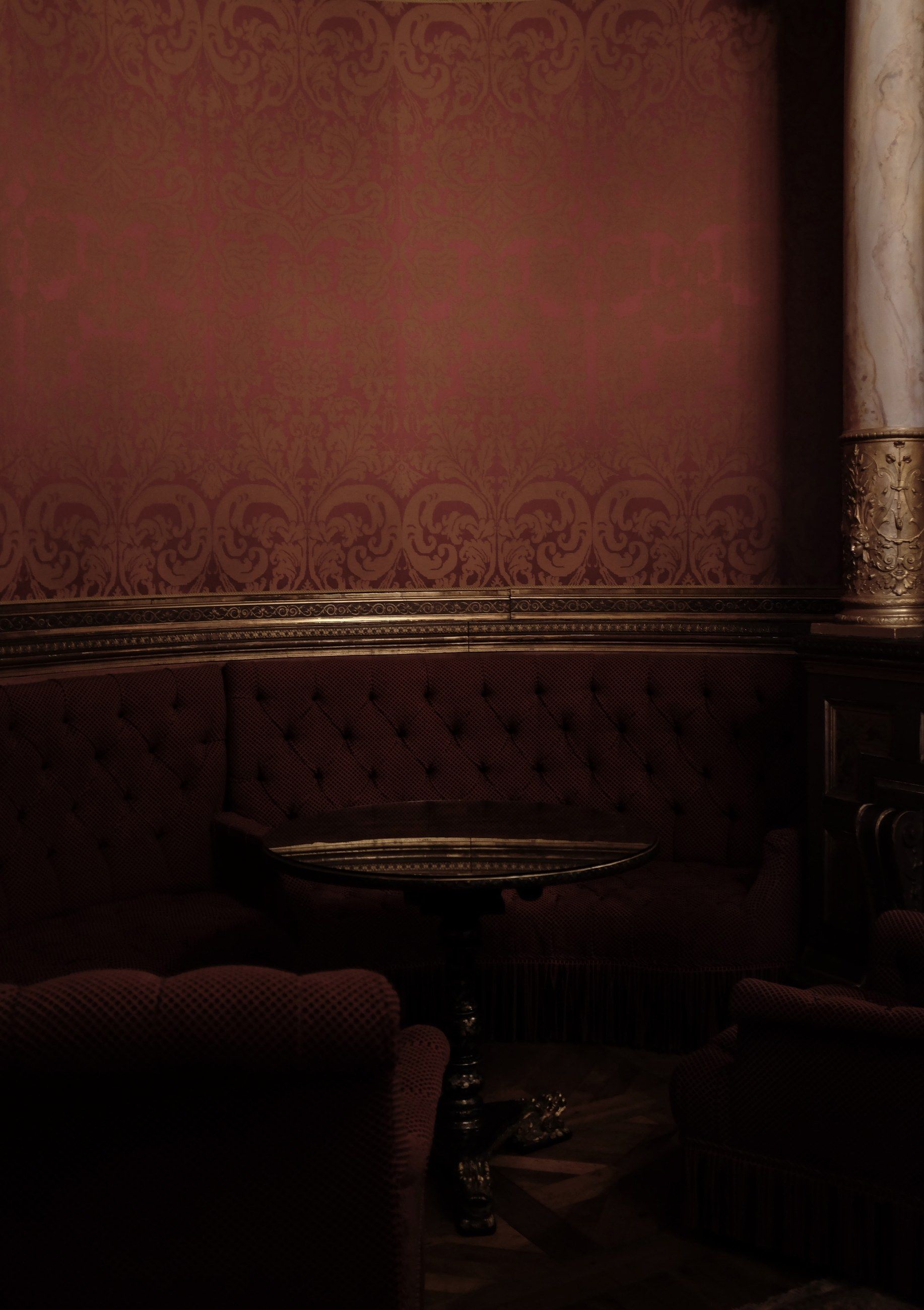 A dark red velvet room with a low sofa