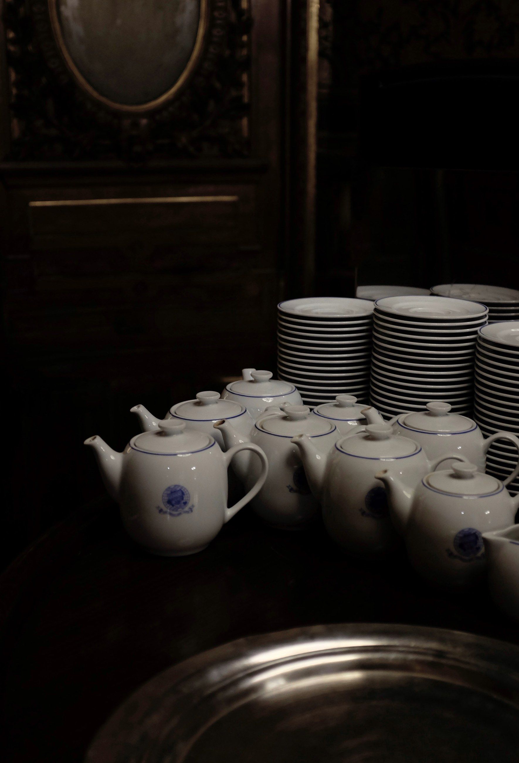 White teapots and stacked plates on a tray