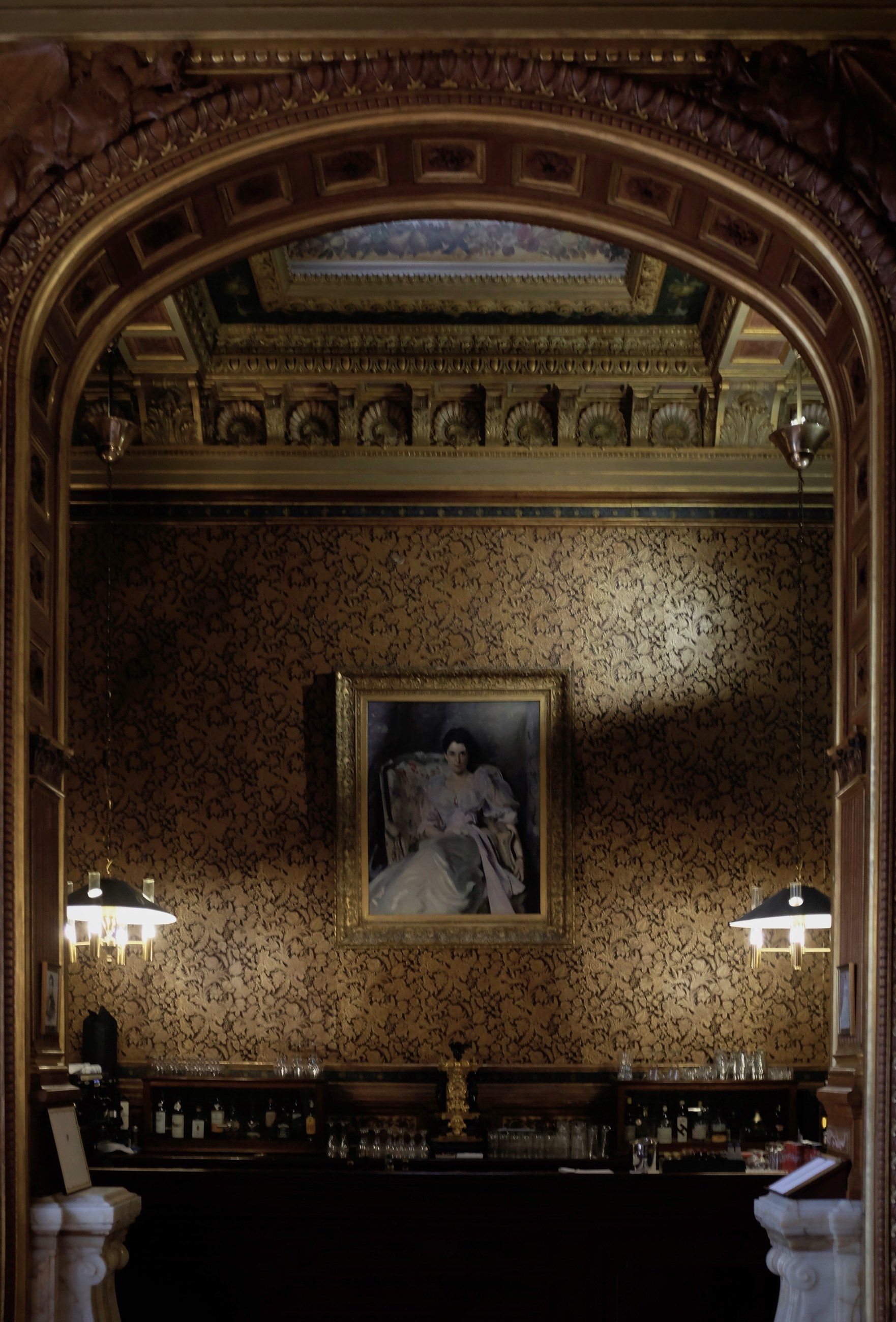 A gilded arch framing a portrait in a mirrored room