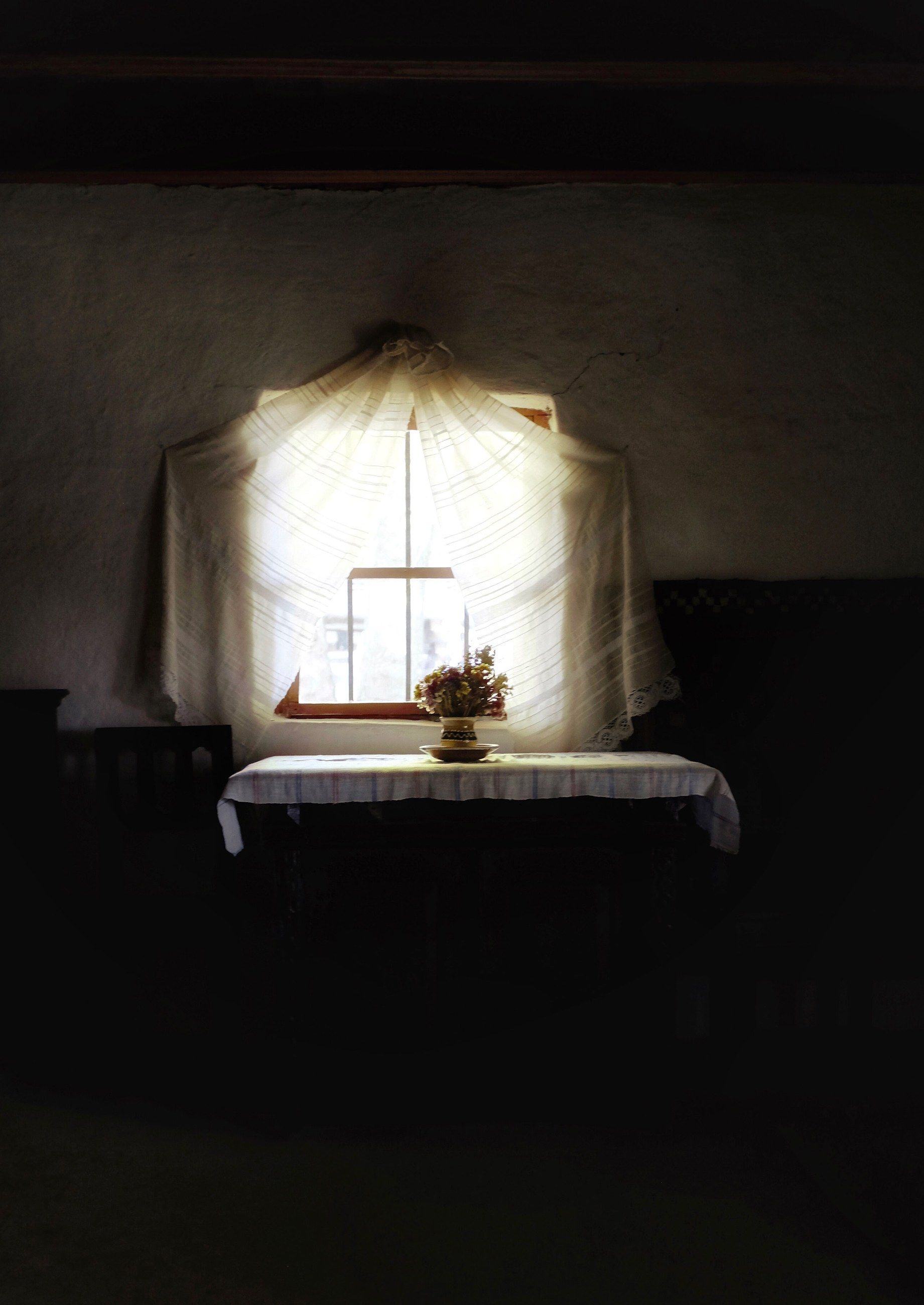 A lace curtain glowing with light above a table